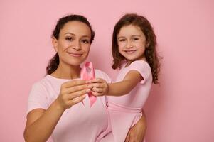 Due generazioni di donne, mamma e figlia abbracciare ogni Altro, Tenere rosa nastro, Seno cancro consapevolezza giorno simbolo, mostrando supporto e solidarietà per pazienti e cancro sopravvissuti. Da donna Salute foto