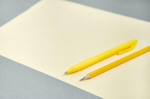 utensili per scrittura e disegno su un' grigio superficie. combinazione di giallo e grigio colori. foto
