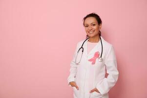 ritratto di africano americano medico nel medico cappotto con rosa nastro, e stetoscopio in giro collo, guardare a telecamera, isolato su colorato sfondo, copia spazio. mondo Seno cancro consapevolezza giorno foto