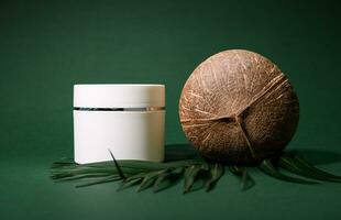 ancora vita con un' Noce di cocco e bianca modello vaso con cosmetico Prodotto su un' palma foglia, isolato su verde sfondo foto
