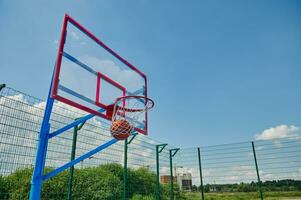 un' pallacanestro palla nel il cestino. punteggio un' obbiettivo su un' estate gli sport terra durante un' pallacanestro gioco foto