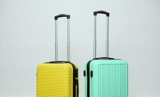 Due luminosa giallo e leggero verde valigie, isolato su bianca studio sfondo. copia spazio. bagaglio. estate vacanze foto