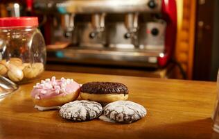 ciambelle e brownies su un' di legno superficie o tavolo su il sfondo di un' caffè macchina. foto