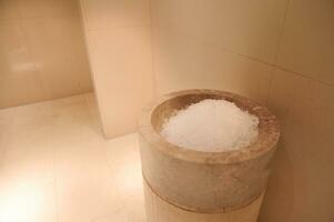 ghiaccio serbatoio nel il lussuoso sala di il bagno e sauna con beige marmo muri. avvicinamento foto