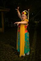 ritratto di un indonesiano ballerino con un' oro cintura danza con grazia foto