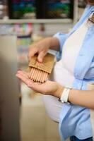 elegante di legno colore matite nel il mani di un' incinta donna shopping per scuola forniture nel scuola Stazionario memorizzare foto