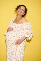 corpo positivo affascinante delizioso incinta donna aspettandosi un' bambino, Tenere pancia e sorridente a grandi linee guardare a telecamera foto