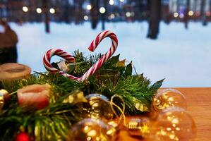 Natale decorazioni. ornamento su un' Natale albero con caramella canne e candele con luci su un' neve coperto sfondo. Visualizza a partire dal il finestra. foto