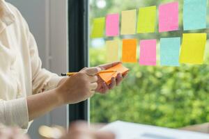 attività commerciale persone Lavorando su appiccicoso Appunti creativo scrittura giù idee su inviare esso Appunti professionale investitore inizio su progetto attività commerciale. foto