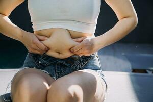 Grasso donna, Grasso gonfiarsi, paffuto, obeso donna mano Tenere eccessivo pancia Grasso con misurare nastro, donna dieta stile di vita concetto foto