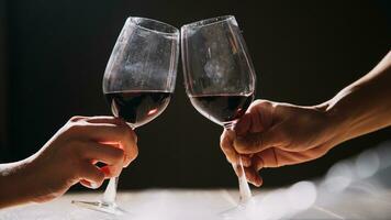 impostato di mani Tenere rosso vino bicchiere isolato su nero sfondo. foto