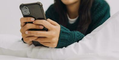 femmina studenti Nota a partire dal il libri a il asiatico ragazza biblioteca seduta a divano utilizzando il computer portatile computer e tavoletta per ricerca un in linea informazioni. nel vivente camera foto