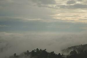 montagna gamma con visibile sagome attraverso il mattina blu nebbia. foto