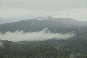 montagna gamma con visibile sagome attraverso il mattina blu nebbia. foto