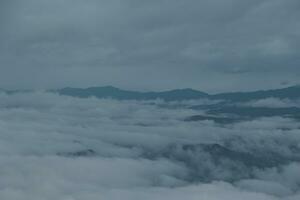 montagna gamma con visibile sagome attraverso il mattina blu nebbia. foto