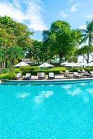 bellissimo ombrellone e sedia intorno alla piscina in hotel e resort