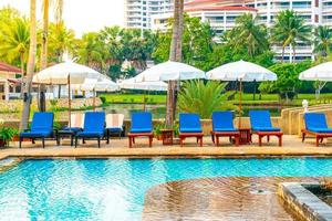 bellissimo ombrellone e sedia intorno alla piscina in hotel e resort