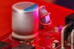 circuito stampato elettronico con componenti elettronici in rosso foto