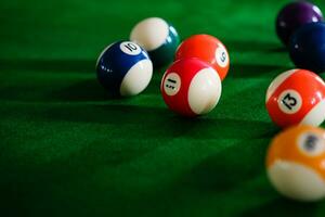 dell'uomo mano e spunto braccio giocando snooker gioco o preparazione mirando per sparare piscina palle su un' verde biliardo tavolo. colorato snooker palle su verde fregio. foto