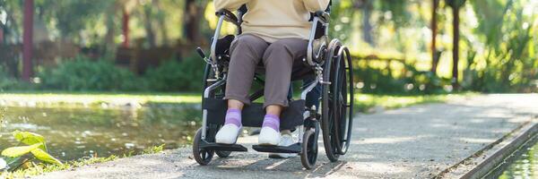 assistenza infermieristica casa. giovane badante porzione anziano donna nel sedia a rotelle. foto