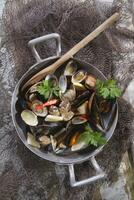 un' padella pieno con cozze e altro frutti di mare foto