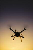 Quadrocopter nel volo a tramonto foto