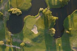 aereo Visualizza di un' verde golf corso a tramonto foto