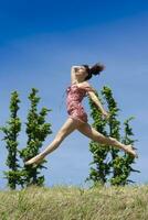 ragazza salto nel natura nel primavera stagione foto