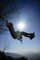 ragazza tiro contro il leggero mentre avendo divertimento su il swing foto