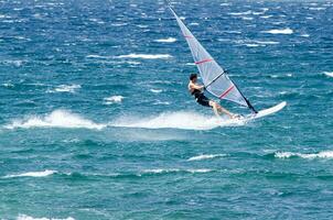 un' uomo windsurf nel il oceano foto