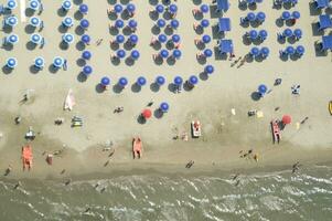 un' spiaggia con molti persone su esso foto