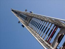 un' alto metallo Torre con un' blu cielo nel il sfondo foto