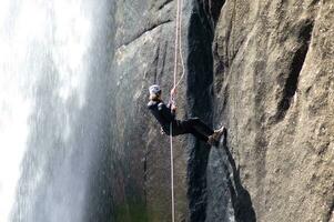 un' persona su un' corda arrampicata su un' cascata foto