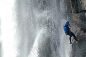 un' persona su un' corda arrampicata su un' cascata foto