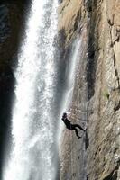 un' persona su un' corda arrampicata su un' cascata foto