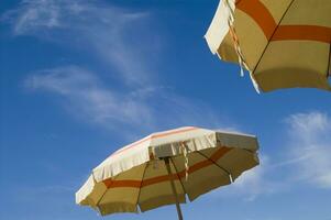un' spiaggia ombrello con un' a strisce copertina foto