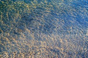 il acqua è chiaro e blu con sabbia foto