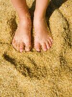 un' paio di piedi su un' sabbioso spiaggia foto