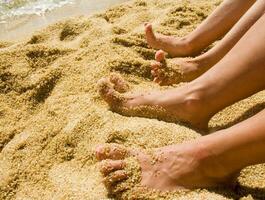 un' paio di piedi su un' sabbioso spiaggia foto