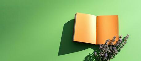 un arancia libro o taccuino con lavanda fiori dentro è In primo piano su un' verde sfondo con foto