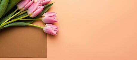 un' giallo tulipano mazzo è visualizzato su un' sughero Nota tavola contro un' rosa sfondo. vuoto spazio foto