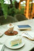 Noce di cocco torta e caffè nel un' bar su il sfocatura sfondo. tradizionale dolce affettato di delizioso Noce di cocco strato torta foto