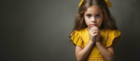 infelice giovane ragazza nel giallo vestito mani di viso contro grigio fondale foto