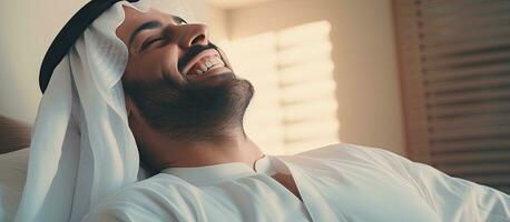 un arabo uomo bene riposato veglia su sorridente e godendo un' piacevole mattina nel letto foto