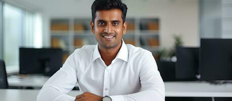 fiducioso indiano uomo d'affari sorridente a telecamera nel ufficio copia spazio foto