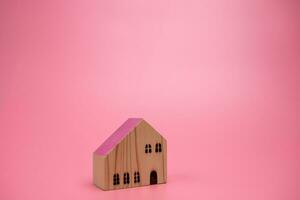 legna Casa modello su rosa sfondo , gestione proprietà investimento concetto, bandiera sfondo foto