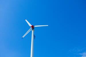 il vento turbina genera un l'ambiente amichevole elettricità nel il luminosa blu cielo. foto
