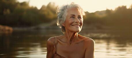 anziano signora godendo natura di il fiume nel estate assaporando semplice piaceri foto