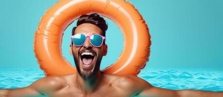 sorridente uomo promuove estate Prodotto indossare occhiali da sole e t camicia con gonfiabile cerchio in giro il suo collo ragnatela bandiera foto