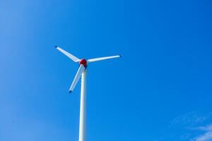 il vento turbina genera un l'ambiente amichevole elettricità nel il luminosa blu cielo. foto